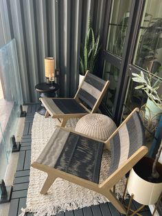 two lounge chairs sitting on top of a wooden floor next to a potted plant