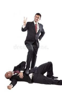 two men in suits are standing on one another and the other is laying down with their hands up