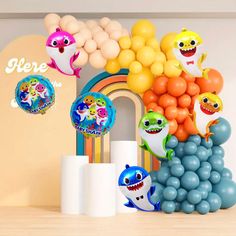 there are many balloons and decorations on the shelf in front of the wall that is decorated with cartoon characters