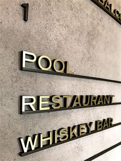 the sign on the wall says pool restaurant whissey bar and has gold lettering