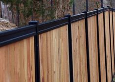 a wooden fence with black metal posts