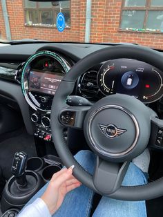 the interior of a car with steering wheel, dashboard and display screen showing various electronic devices