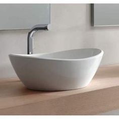 two white bowls sitting on top of a counter next to each other in front of mirrors