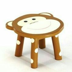 a small wooden stool with a monkey design on the top and polka dots on the bottom