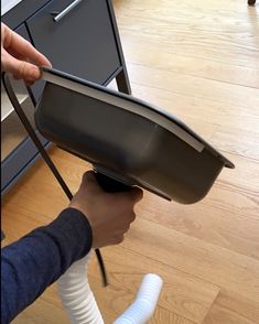 a person is holding an open dishwasher in their hand, with the lid up