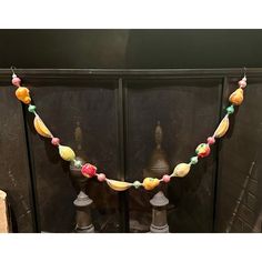 a string of fruit is hanging from the side of a fireplace