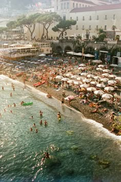 many people are swimming in the water at this beach