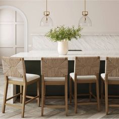 a kitchen table with four chairs and a potted plant on top of the counter