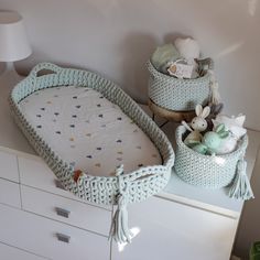 a crib with two baskets on top of it and stuffed animals in the bottom