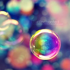 some bubbles are floating in the air on a blue and green background with multicolored circles