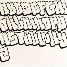 the upper and lower letters are drawn in black ink on white paper, which has been cut into smaller shapes