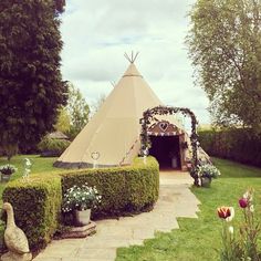 a teepee tent in the middle of a garden