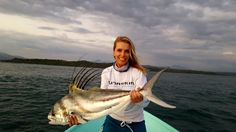 a woman on a boat holding a fish