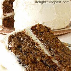 a close up of a slice of cake with white frosting on a plate next to a fork