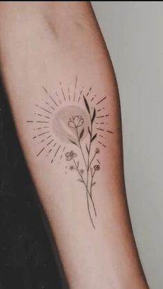 a woman's arm with a flower tattoo on it