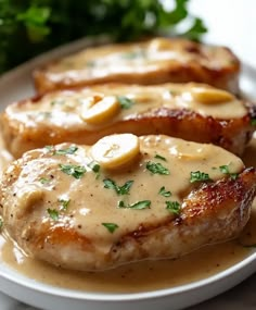 two pieces of meat covered in gravy on a plate