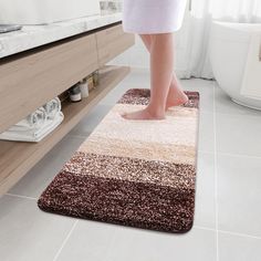 a person standing on a bathroom rug in front of a sink