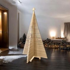 a large wooden christmas tree sitting on top of a hard wood floor