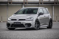 the volkswagen golf gtr is parked in front of a building