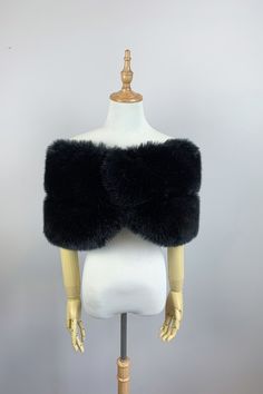 a mannequin wearing a black fur vest on top of a white dress form