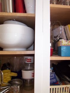 a kitchen cupboard filled with lots of clutter