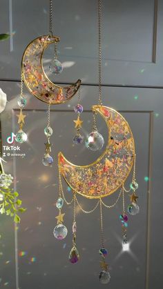 the moon and stars are hanging from chains