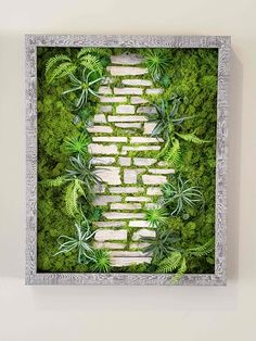 an aerial view of a brick path surrounded by green plants in a frame on the wall