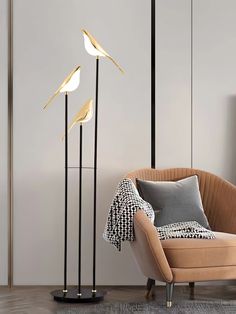 three floor lamps in the corner of a room with a chair and throw pillow on it