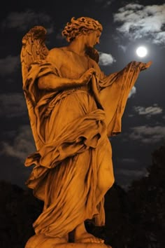 an angel statue with the moon in the background