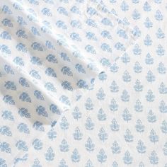 an unmade sheet with blue flowers on it