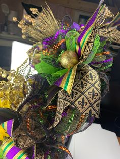 a close up of a bunch of different colored ribbons on a white table cloth with gold, green and purple decorations in the background