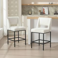 two white chairs sitting next to each other in a kitchen