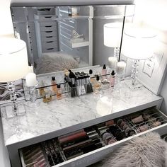 a vanity with makeup and candles in it