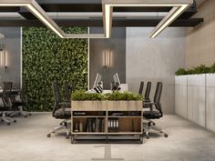 an office with tables, chairs and plants on the wall in it's center