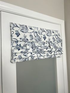 a blue and white window valance hanging on the side of a door