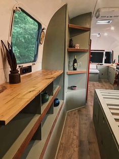 the interior of an airstream with shelves, cabinets and counter tops on each side