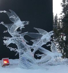 an ice sculpture in the snow with a red light on it's left side