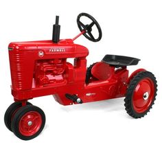 a red toy tractor sitting on top of a white surface