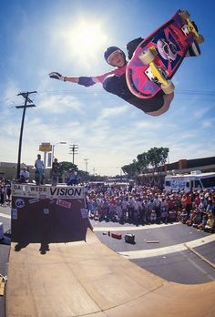 a man riding a skateboard up the side of a ramp in front of a crowd