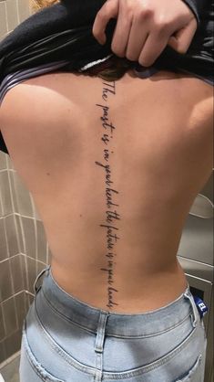 the back of a woman's body with writing on her lower back and upper part