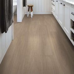 a bathroom with white cabinets and wood flooring