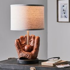 a lamp that is sitting on top of a table next to a book and some books