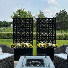 an outdoor fire pit surrounded by wicker chairs and flowered planters on a patio