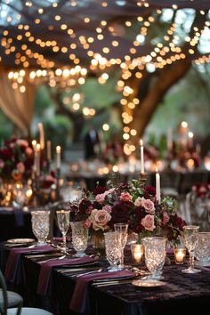 the table is set with candles, flowers and wine glasses for an elegant wedding reception