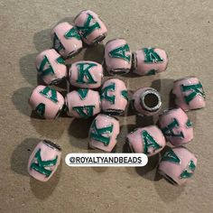 pink and green ceramic beads with letters on them