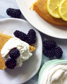 there is a piece of cake with whipped cream and blackberries on the plate next to it