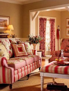 a living room with red and white striped couches, coffee table and ottomans