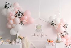 a room filled with lots of pink and white balloons