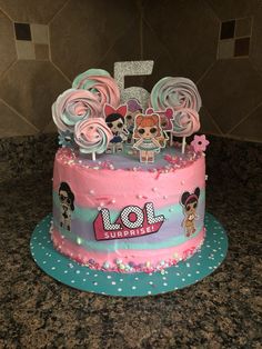 a pink and blue cake with cartoon characters on it