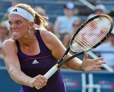 a woman swinging a tennis racquet at a ball